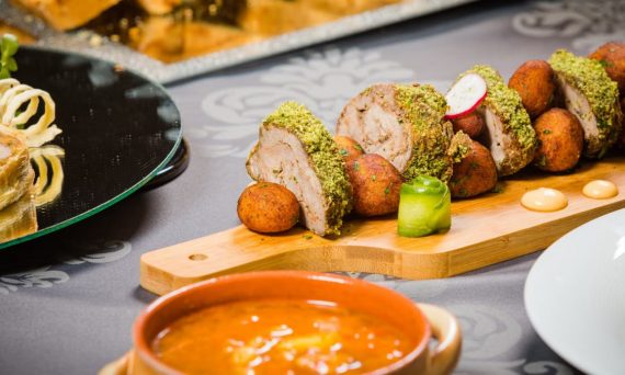 Close-up of a beautifully plated meat dish with various sides, perfect for a refined dining experience.