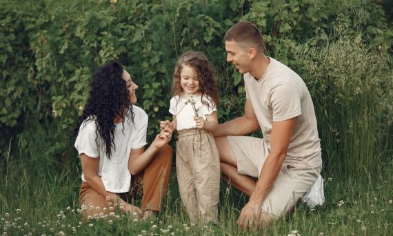 A joyful family enjoying time together in a lush green field.